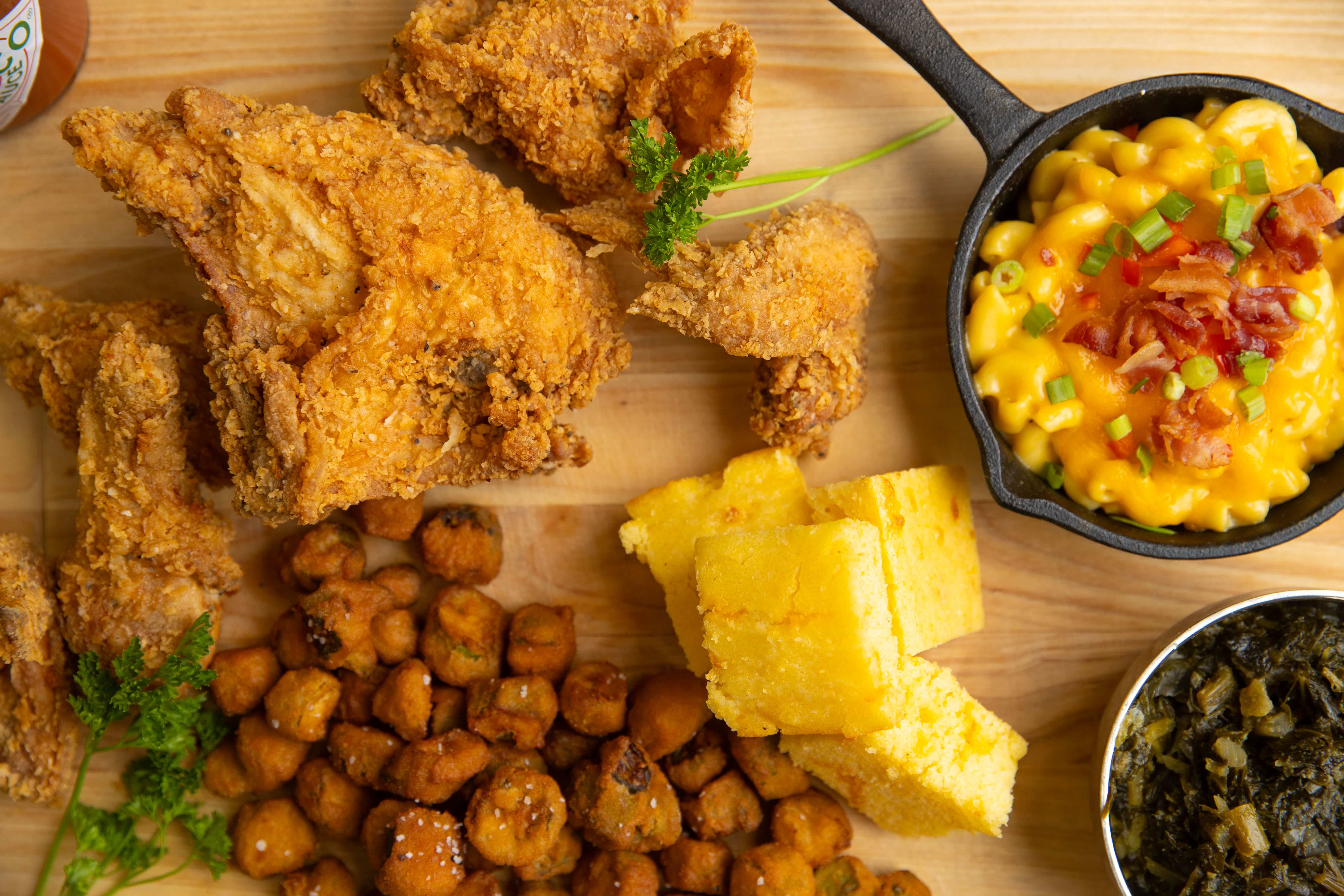 Close-up, top-down photo showing crispy fried chicken, mac and cheese, and other southern comfort food.
