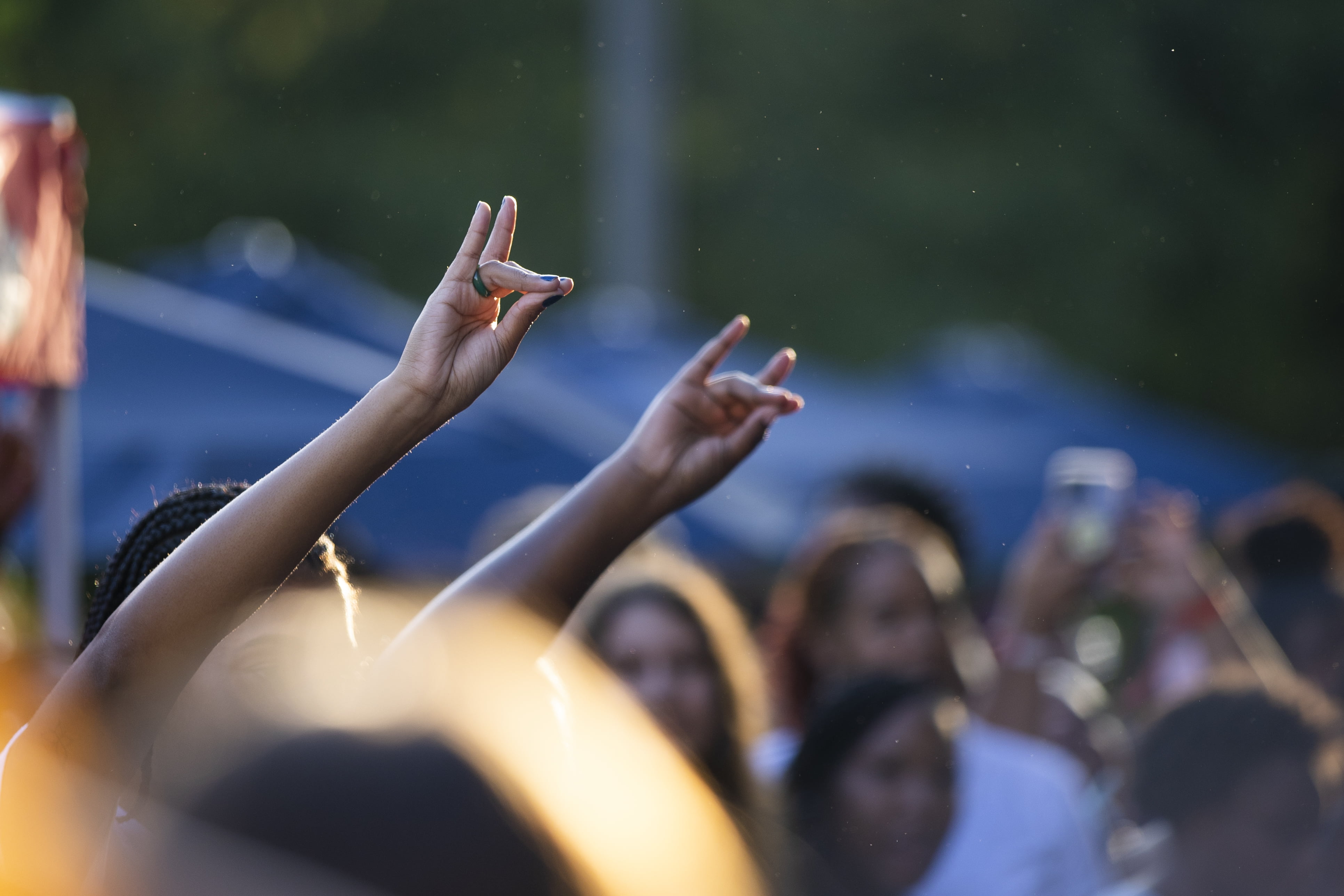 Students raising the wolf-shaped hand sign at an event.