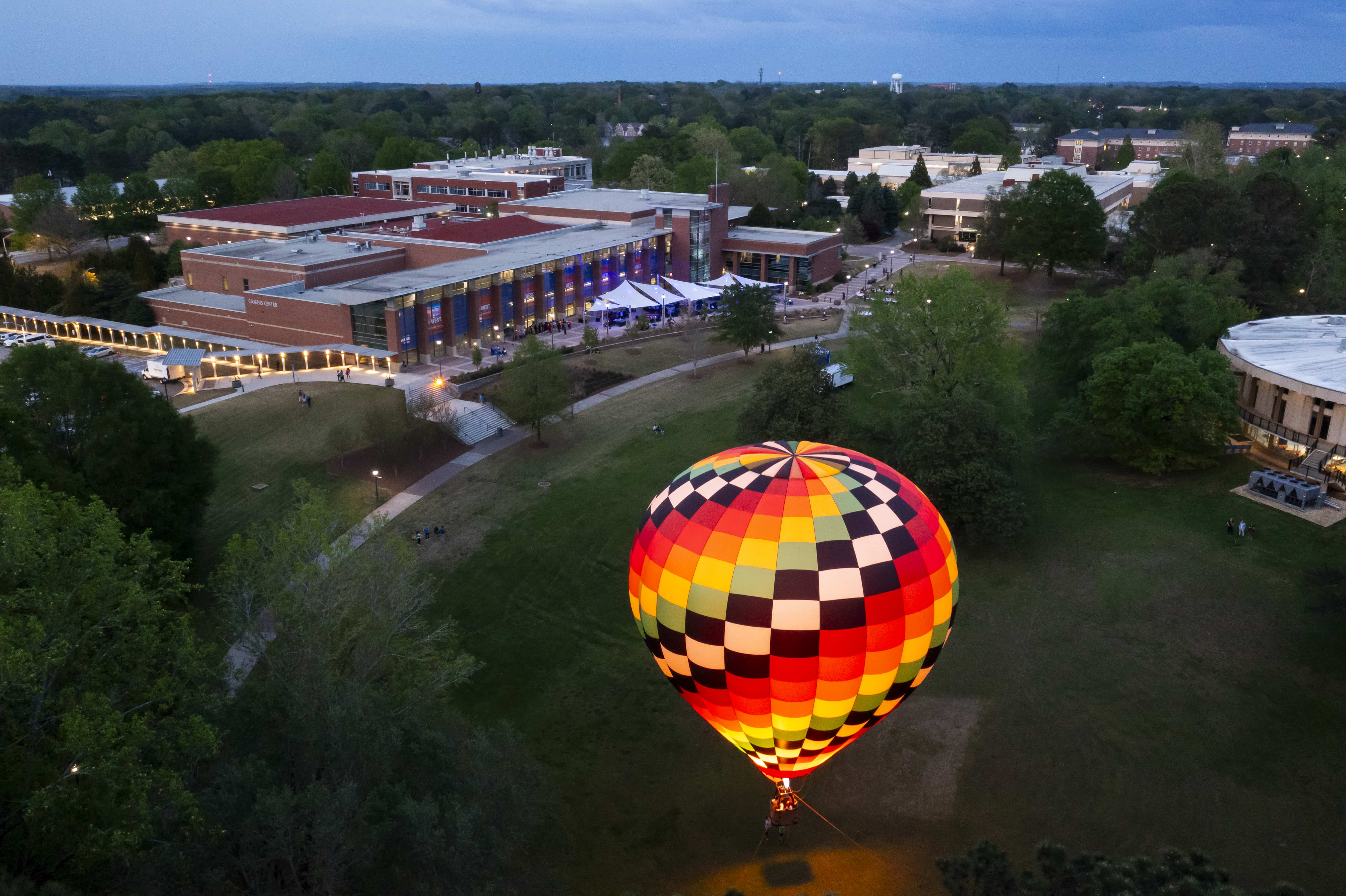 Aeiral photo of Love Valley with a hot air balloon rising off the ground in Love Valley at dusk.