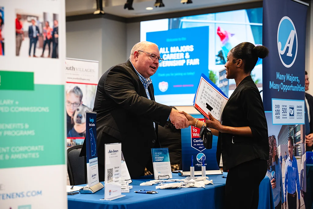student talking to career vendor at career fair