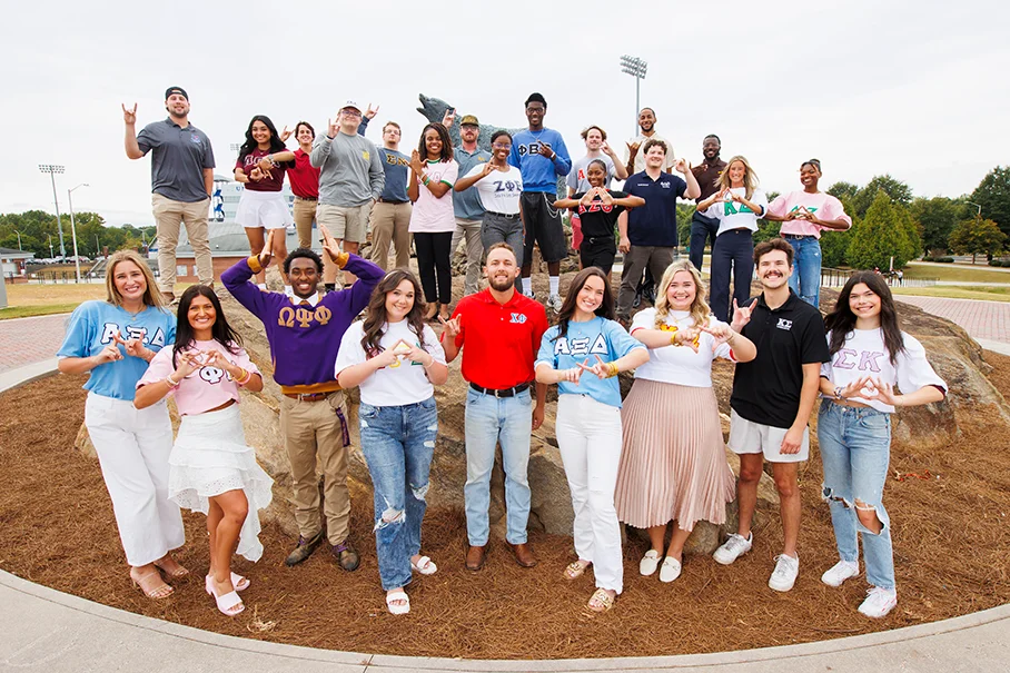 FSL members next to wolf statue