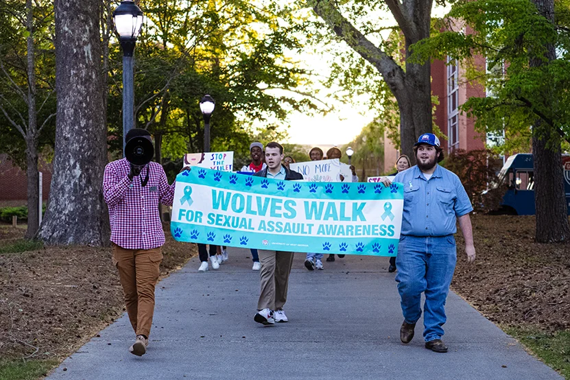 students walking with wolves walk for sexual assault awareness banner
