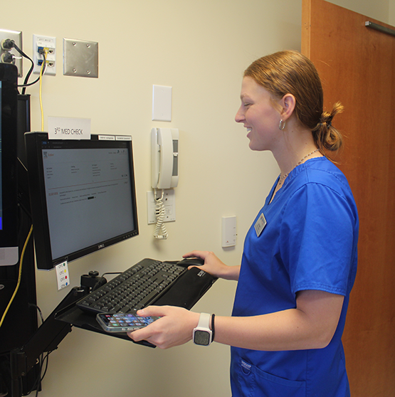 a nursing student taking notes while at a computer