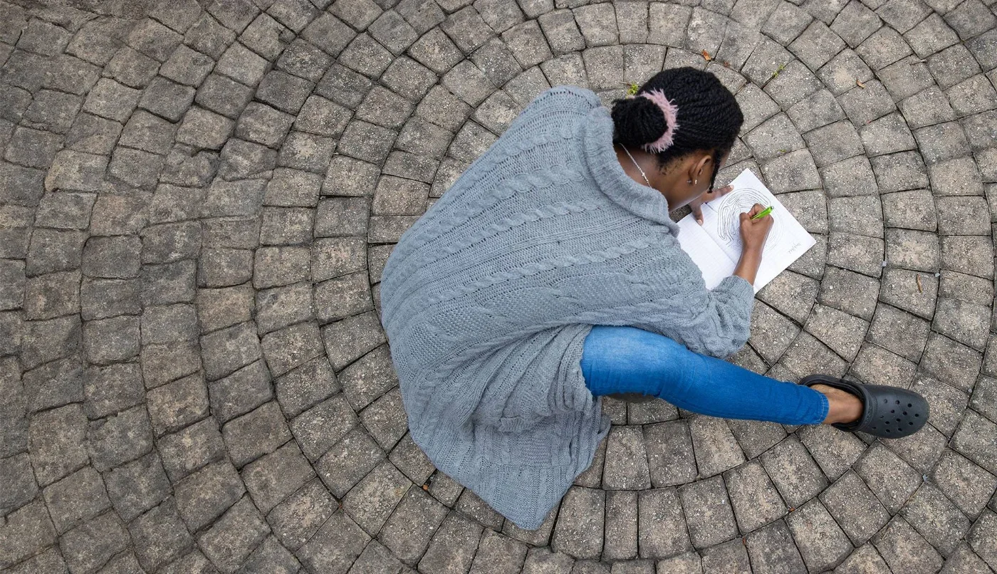 student drawing a brain on circular pavement