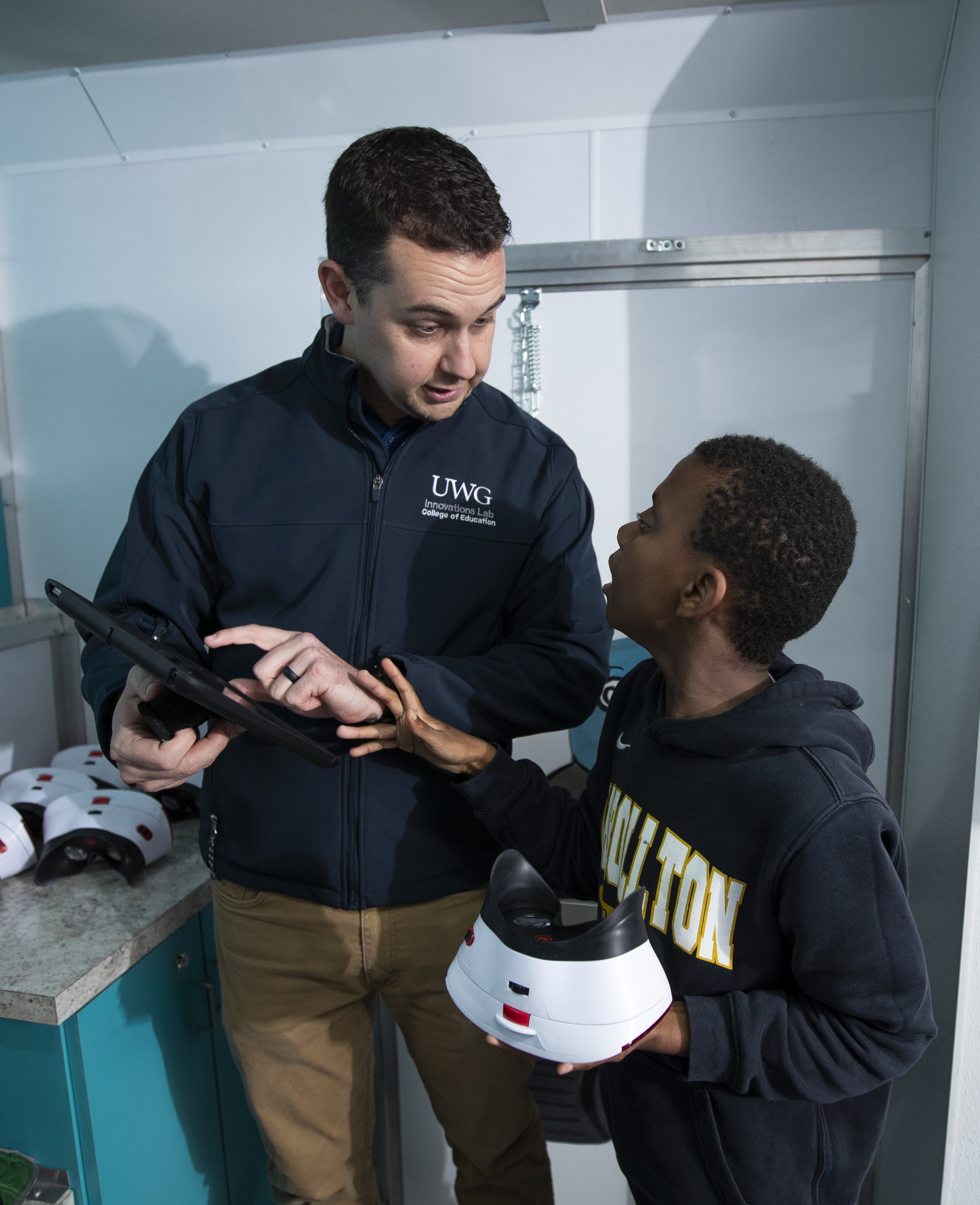 Teacher and child looking at educational virtual reality headsets.