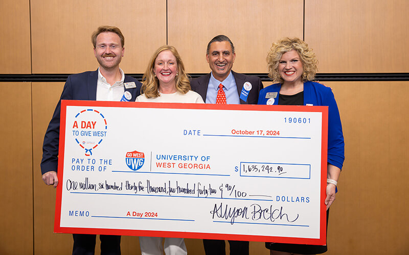 UWG administrators holding a big check for A Day to Give West