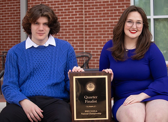 UWG Debate students holding a plaque

