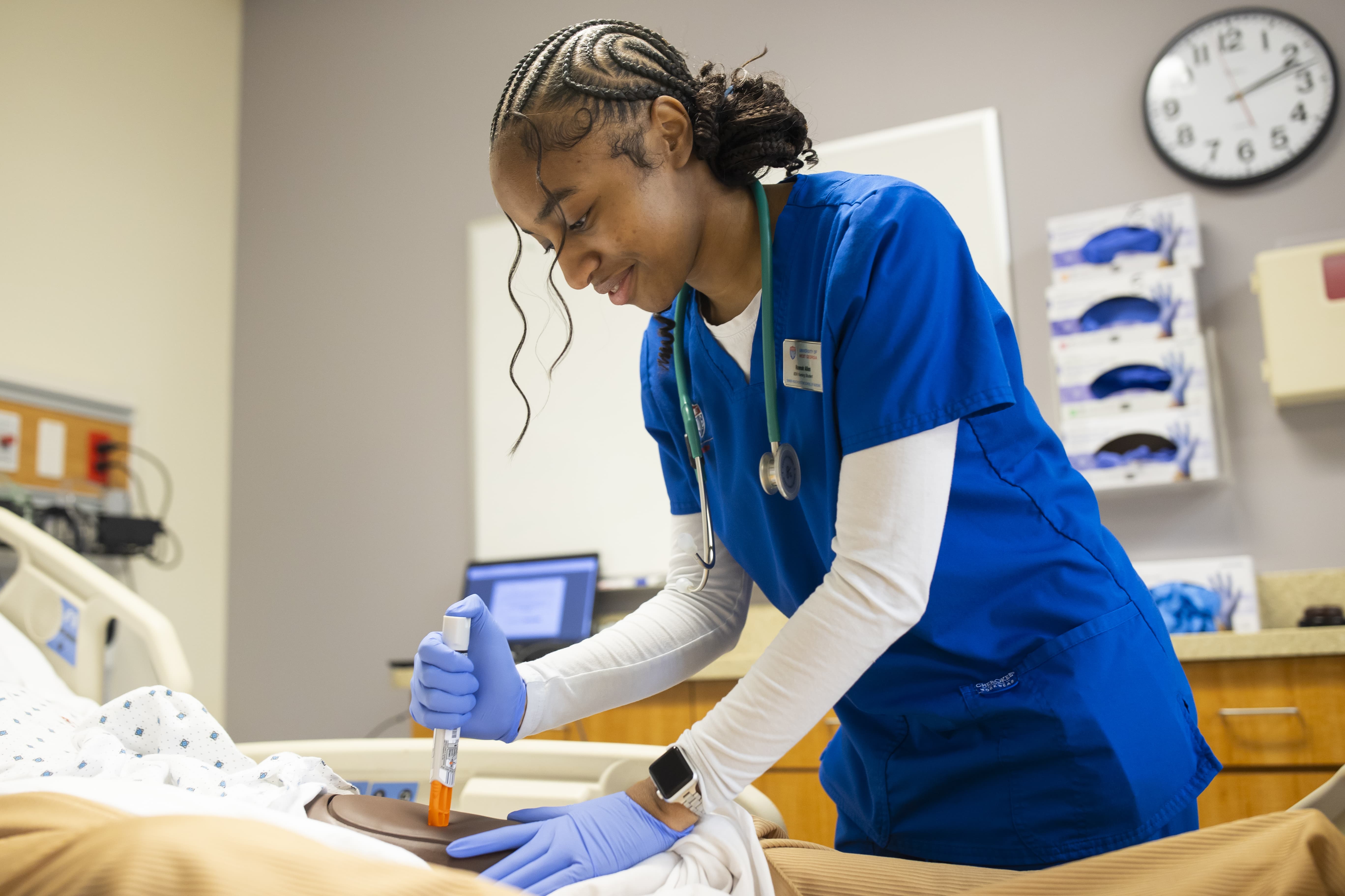 Nursing student working on a simulation dummy.