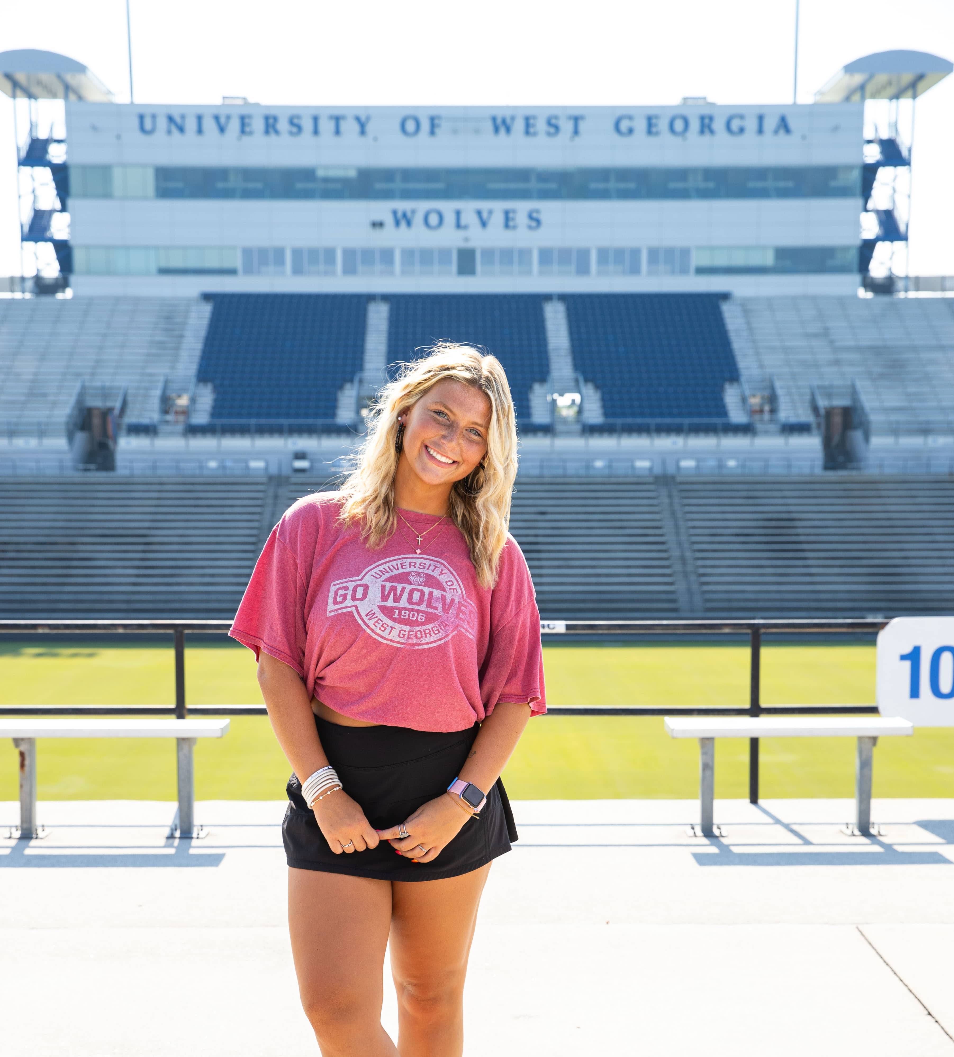 Emily Howie posing for an outside portait in the football stadium.