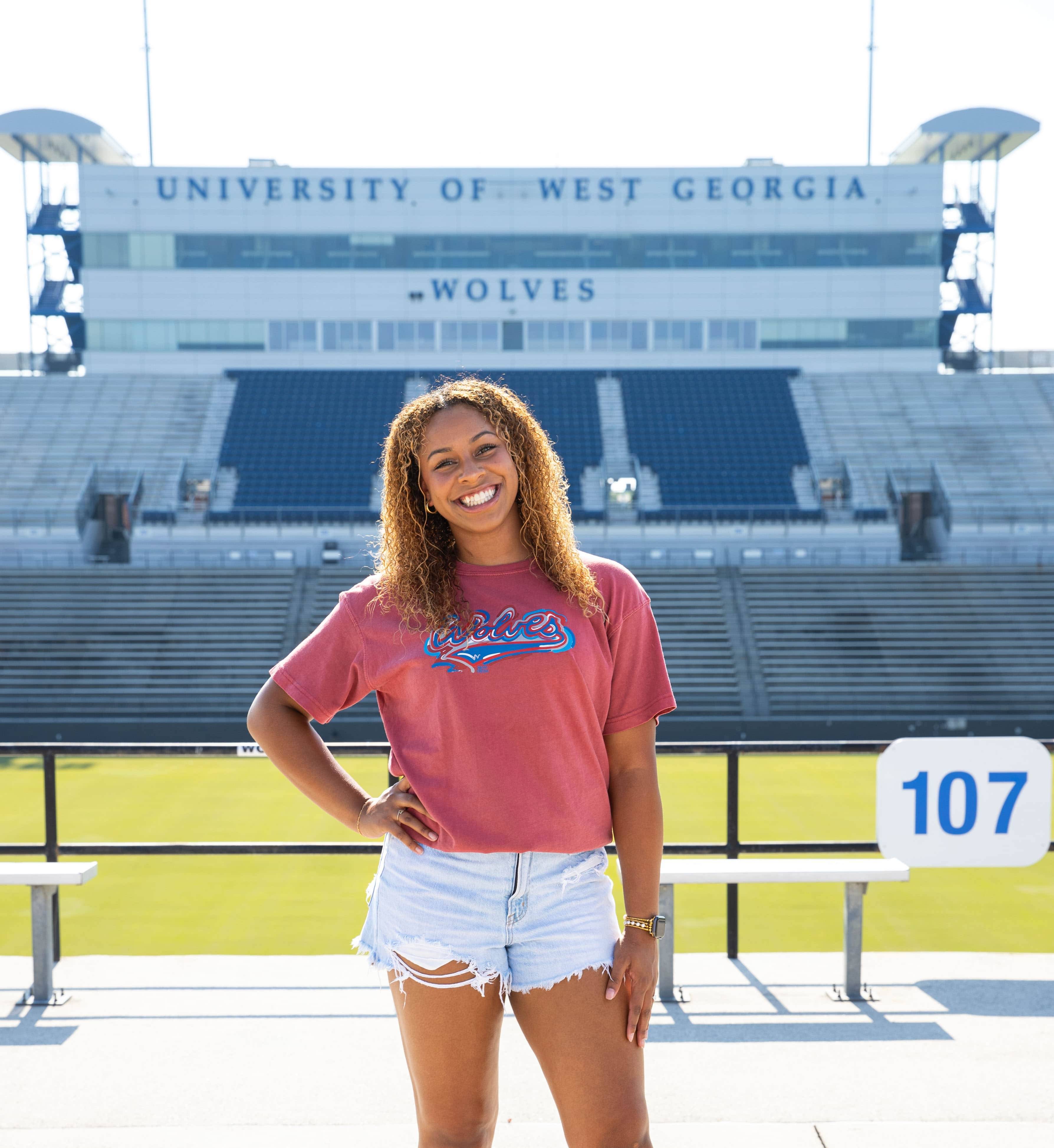 Sydney Blackmon posing for an outside portait in the university stadium.