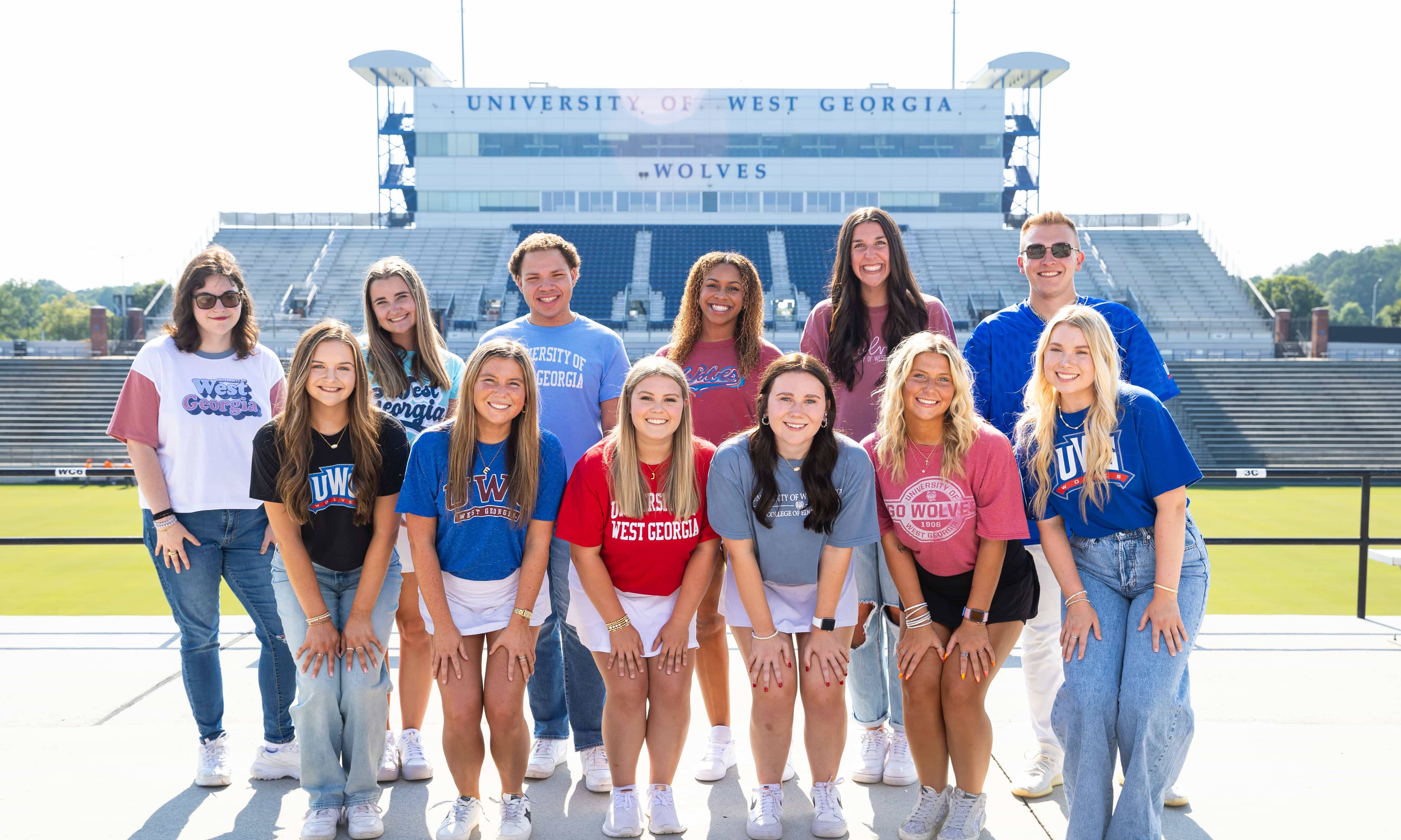 Fall 2024 Social Media Ambassadors pose for a group photo in the stadium.