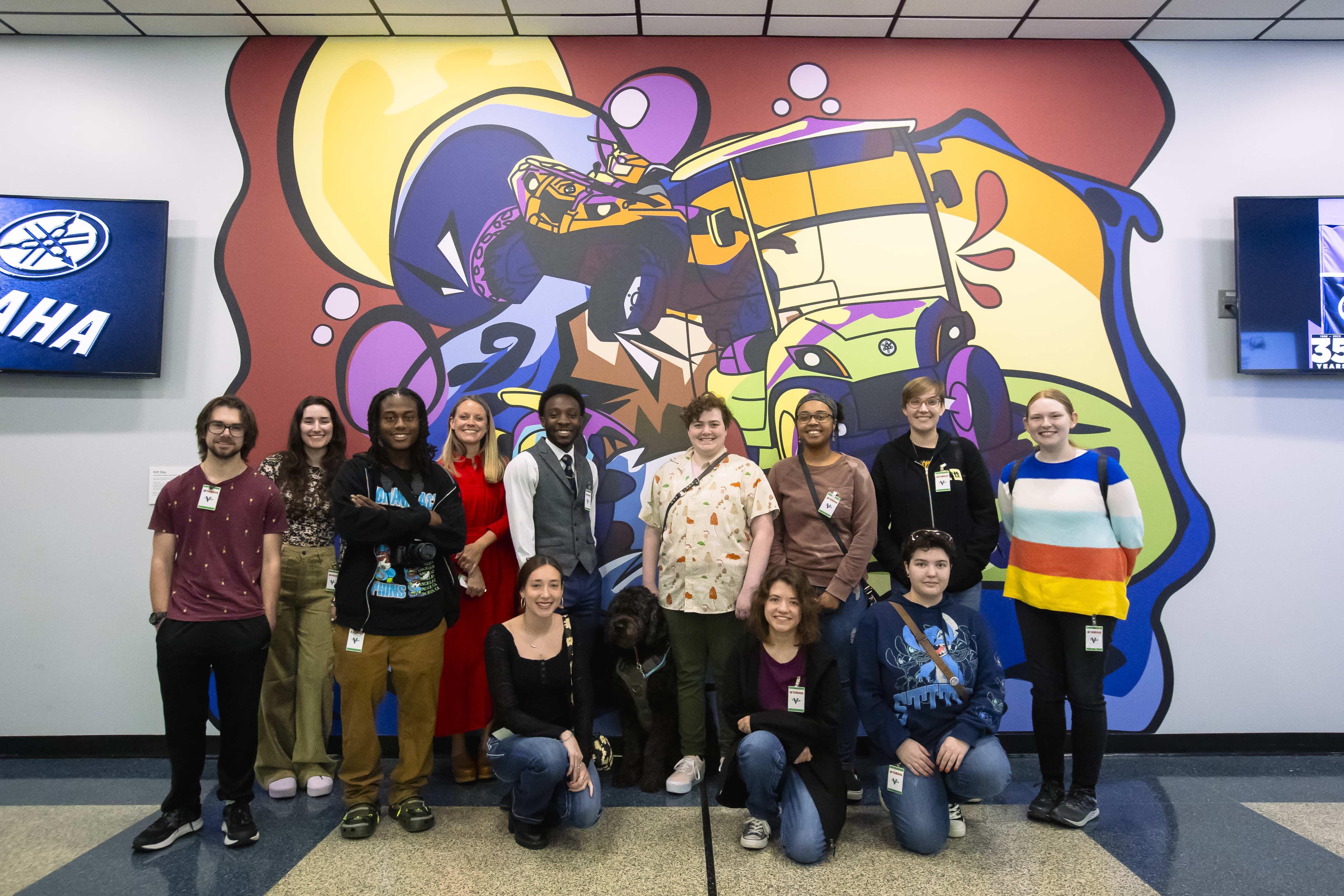 Art students standing in front of the newly painted Yamaha mural in Newnan.