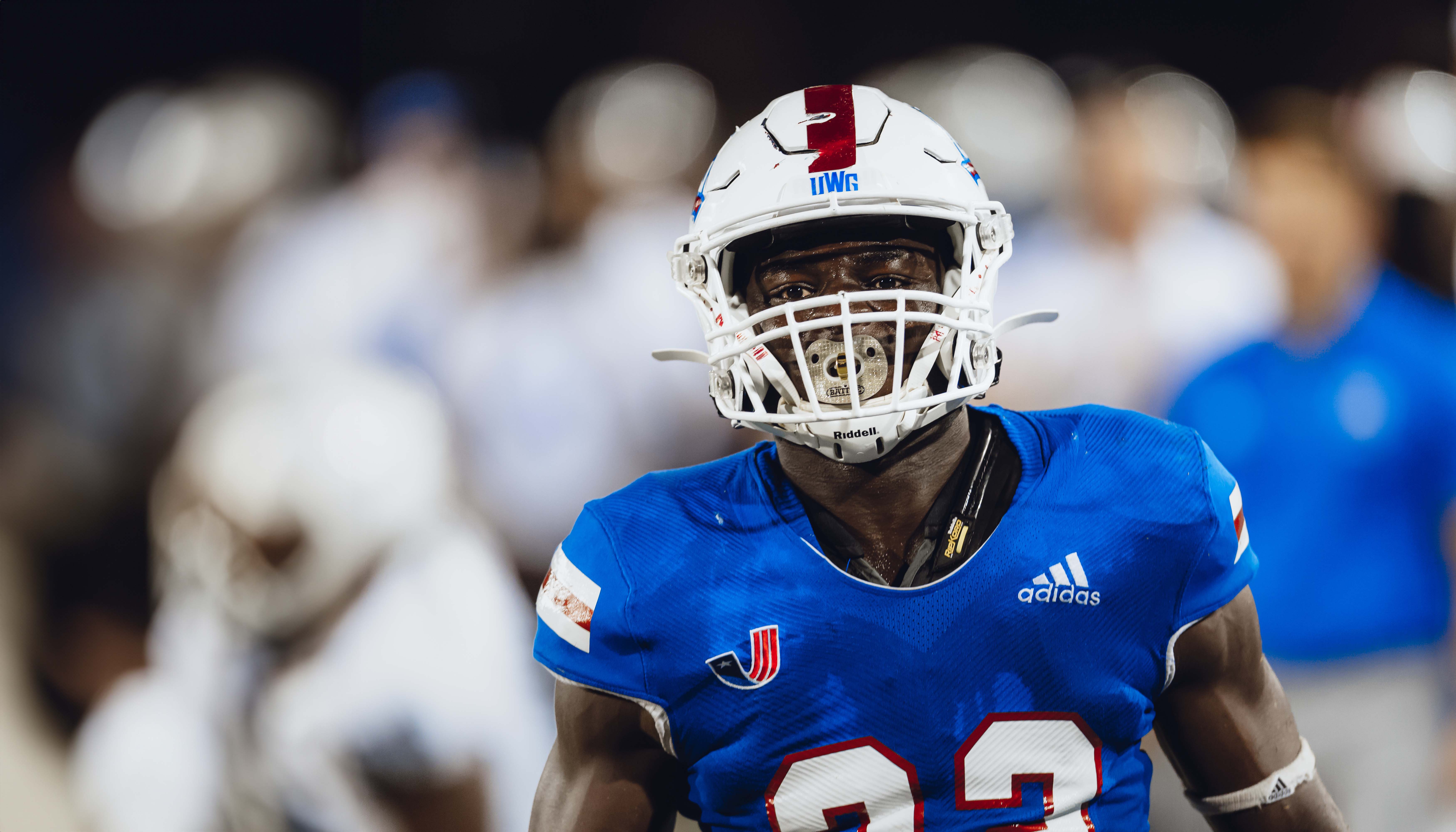 UWG football player in focus with the crowd blurred behind him.